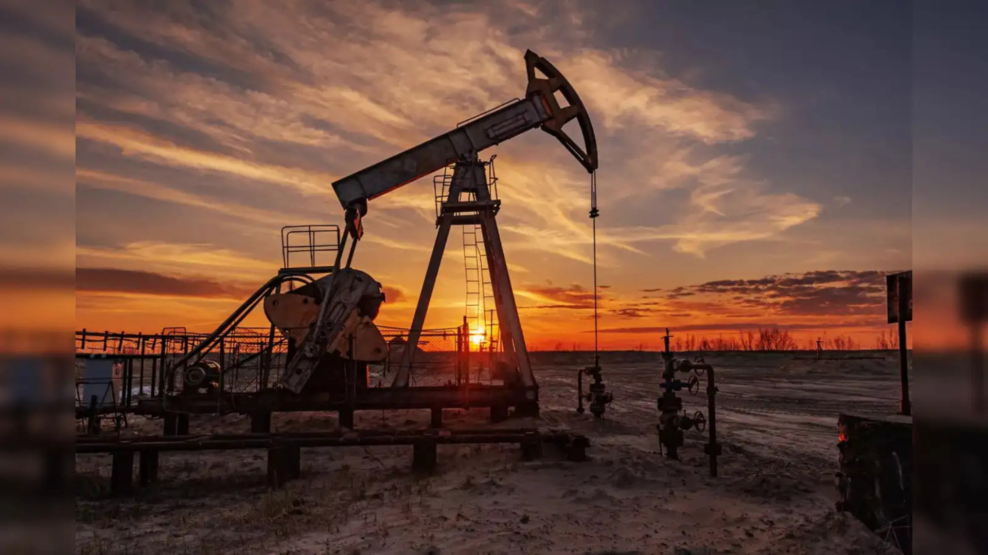 Oil pumpjack at dusk with colorful sky in the background