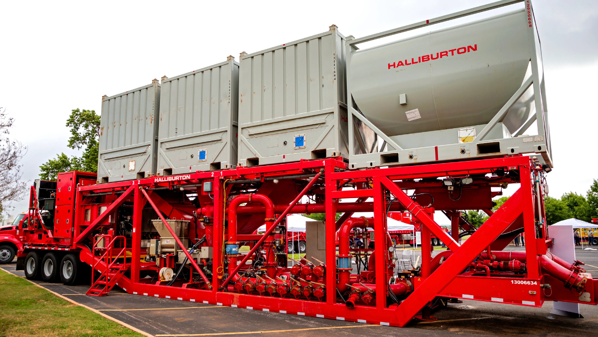 Red Halliburton fracking equipment with storage tanks and piping system.