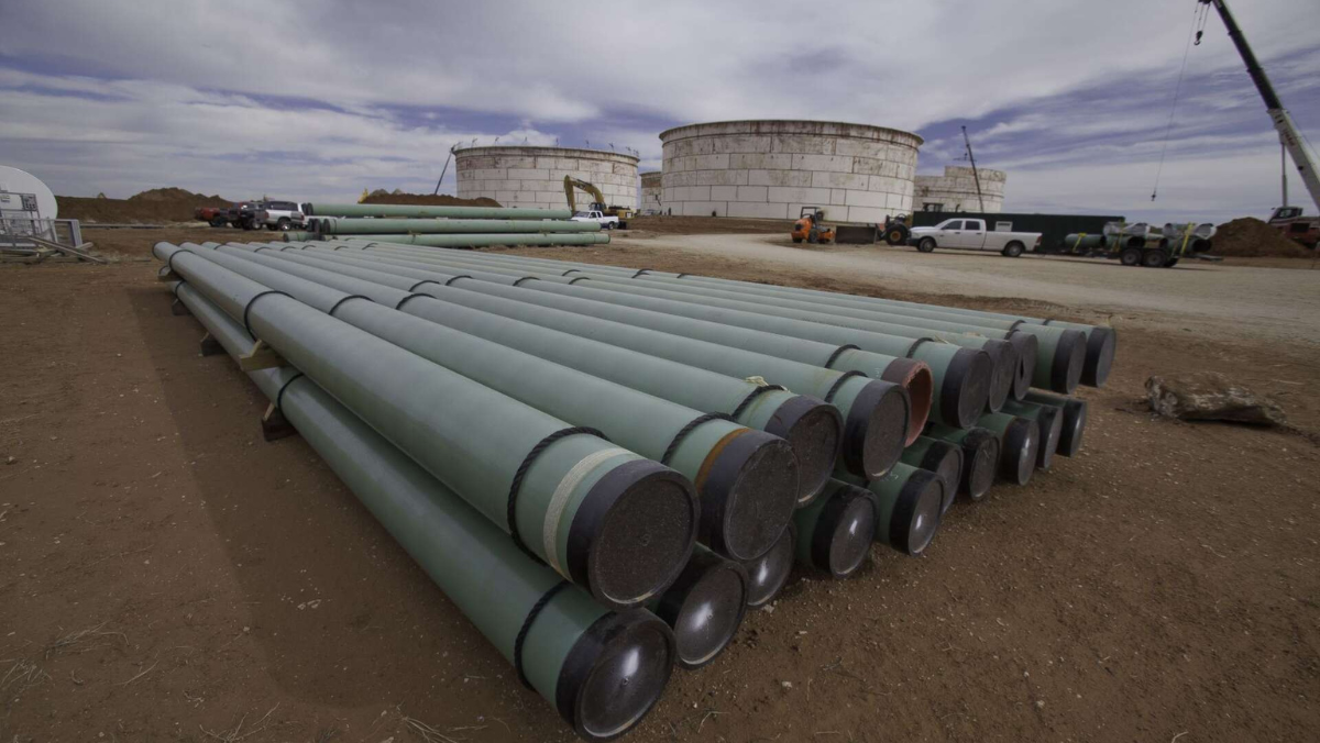 Industrial pipes and large storage tanks at a Texas oilfield water facility.