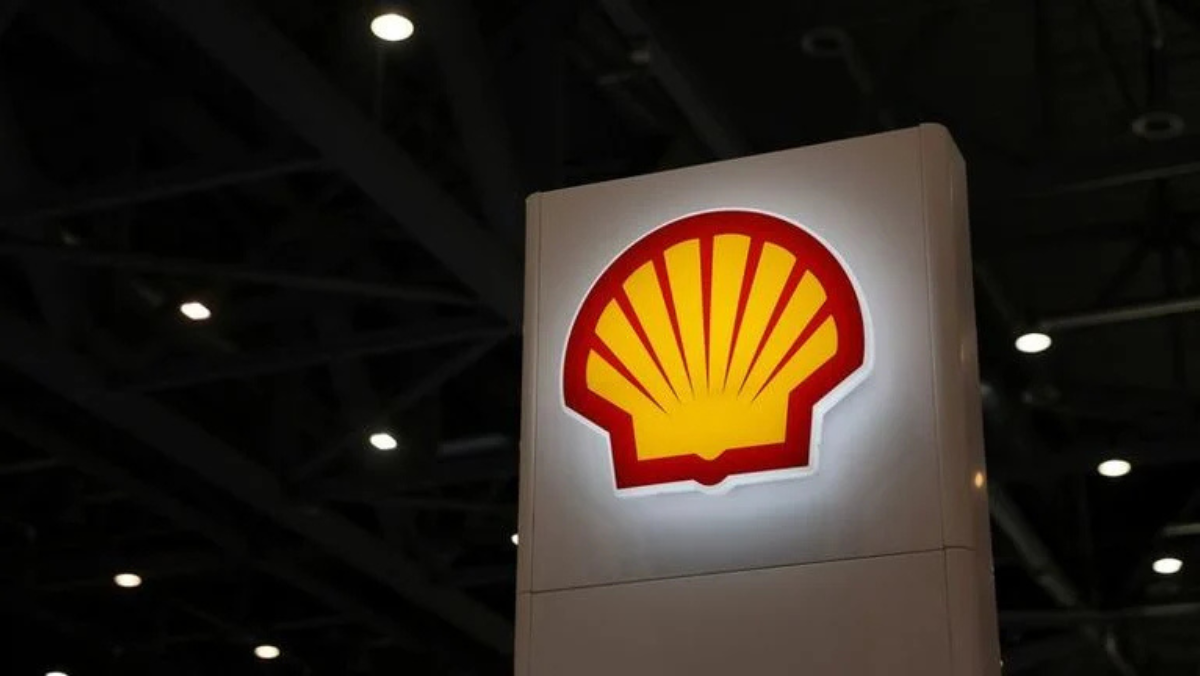 Shell logo illuminated on a sign inside an industrial exhibition hall.
